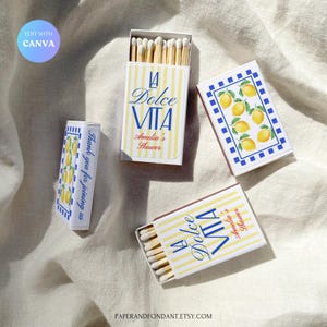 May include: Matchboxes with a lemon design. The boxes display the text "La Dolce Vita" and "Amelia's Shower" in blue and red. One box says "Thank you for joining us". The boxes have yellow and white stripes and a blue and white lemon pattern.