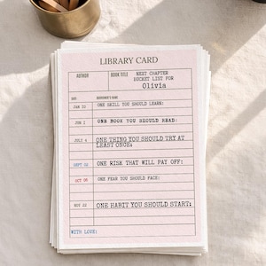 May include: A stack of pale pink paper library cards featuring black printed text. The header reads LIBRARY CARD, followed by NEXT CHAPTER BUCKET LIST FOR Olivia. The grid includes prompts like ONE SKILL YOU SHOULD LEARN and ONE HABIT YOU SHOULD START.