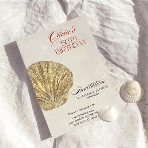 Peut inclure: Une invitation blanche pour un 50e anniversaire avec le texte "Olivia's 50th Birthday" en rouge. Une coquille Saint-Jacques dorée est imprimée sur le devant. Deux coquillages blancs sont également présents.