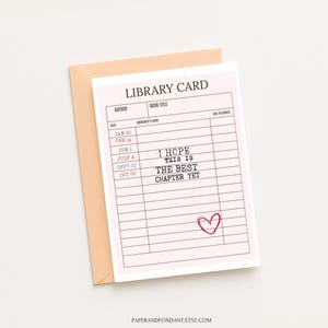 May include: A pink library card design with the text "I HOPE THIS IS THE BEST CHAPTER YET" and a red heart. The card is inside a peach-colored envelope. The Etsy shop name is at the bottom.