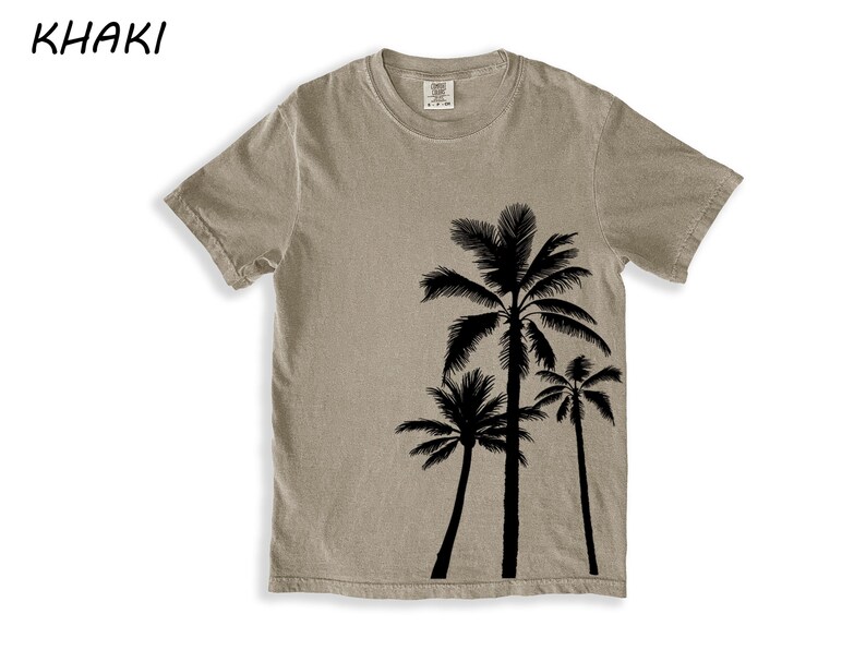 K&ouml;nnte beinhalten: Khaki-farbenes T-Shirt mit einer schwarzen Silhouette von drei Palmen. Das Shirt hat einen Rundhalsausschnitt und kurze &Auml;rmel. Das Wort "KHAKI" ist oben links in Schwarz aufgedruckt.