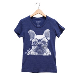 K&ouml;nnte beinhalten: Ein marineblaues T-Shirt mit einem wei&szlig;en Grafikdruck eines franz&ouml;sischen Bulldoggen, der eine runde Brille tr&auml;gt. Der Text "by Coult" ist unter dem Bild gedruckt.