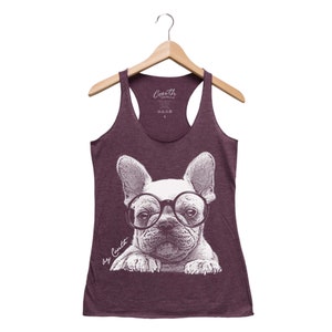 May include: A maroon racerback tank top with a white graphic of a French bulldog wearing round glasses. The text "by Courth" is printed on the bottom left of the graphic.
