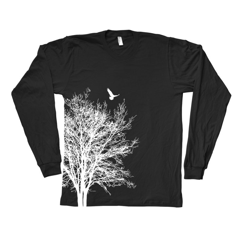 May include: Black long-sleeved t-shirt featuring a white silhouette of a tree and a bird flying above it.