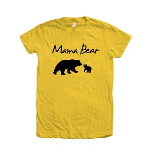 May include: Yellow t-shirt with the text "Mama Bear" in black script. A black silhouette of a mama bear and a baby bear are below the text.
