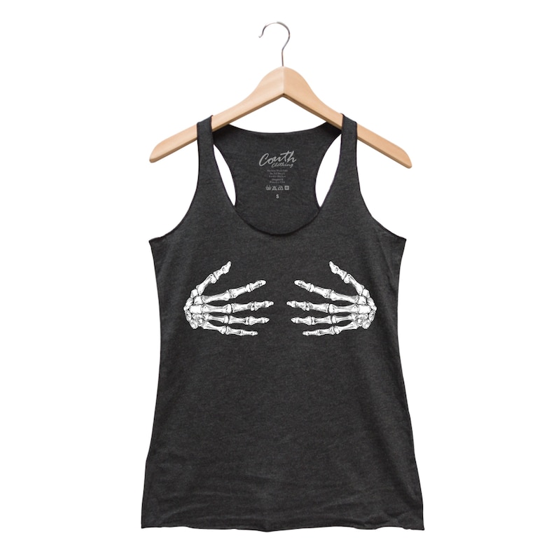 May include: Dark gray racerback tank top featuring a white skeleton hand graphic. The tank top is hanging on a wooden hanger. The brand name "Couth Clothing" is printed on the tag.