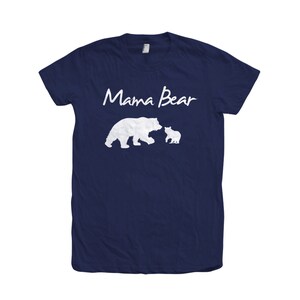 May include: A navy blue t-shirt with the text "Mama Bear" in white script. The shirt features a white silhouette of a mother bear and a cub.