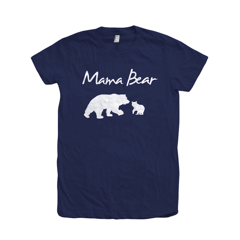 May include: A navy blue t-shirt with the text "Mama Bear" in white script. The shirt features a white silhouette of a mother bear and a cub.