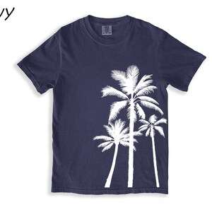 K&ouml;nnte beinhalten: Marineblaues T-Shirt mit wei&szlig;em Palmen-Design. Das T-Shirt hat einen Rundhalsausschnitt und kurze &Auml;rmel. Das Wort "NAVY" befindet sich in der oberen linken Ecke. Dieses l&auml;ssige T-Shirt ist ideal f&uuml;r ein Strand- oder Tropen-Thema.