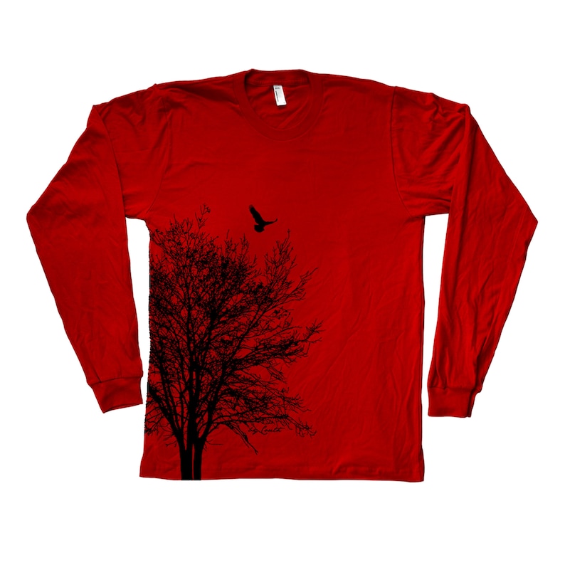 May include: Red long-sleeved t-shirt featuring a black silhouette of a tree and a bird in flight above it.