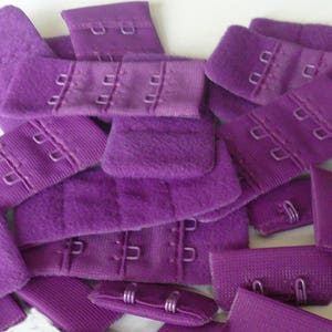 Peut inclure: Un tas d'extensions de bretelles de soutien-gorge violettes avec des crochets métalliques. Les extensions sont faites d'un tissu doux et extensible.