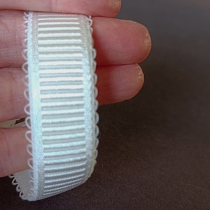 Peut inclure: Ruban &eacute;lastique blanc avec un bord festonn&eacute; et une texture c&ocirc;tel&eacute;e.