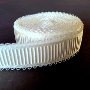 Peut inclure: Un rouleau de galon blanc d&eacute;coratif avec un bord festonn&eacute; et une texture c&ocirc;tel&eacute;e.