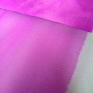 May include: A close-up of a bright pink sheer fabric with a subtle texture. The fabric is folded over, revealing a lighter shade of pink underneath.