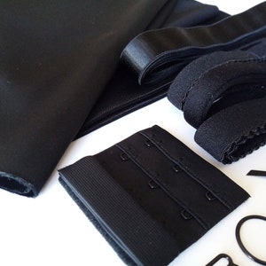 Könnte beinhalten: Schwarzer Stoff, Gummiband und BH-Bügel für Nähprojekte.