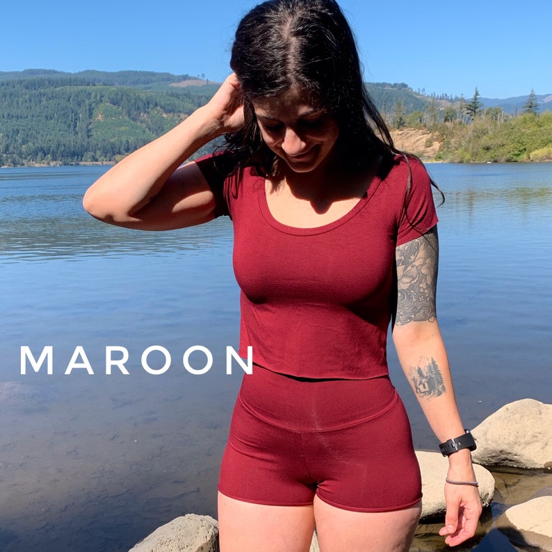 May include: A maroon crop top and matching shorts set. The top has a scoop neckline and short sleeves. The shorts have a high waist and a relaxed fit.
