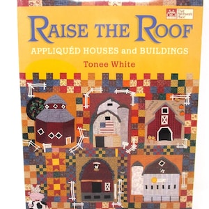 May include: A softcover book titled Raise the Roof: Appliquéd Houses and Buildings by Tonee White. The cover features a colorful patchwork quilt background with various appliquéd barn and house designs, including a red barn with an American flag.