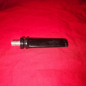 Puede incluir: Una boquilla de pipa de plástico negro con un conector de metal plateado.