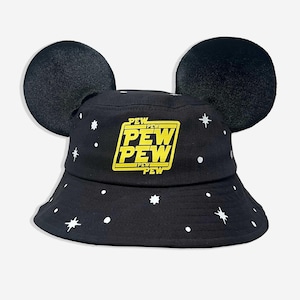 May include: Black bucket hat with attached black mouse ears. The hat features white star and dot patterns, and a yellow and black rectangular graphic that reads "PEW PEW PEW".