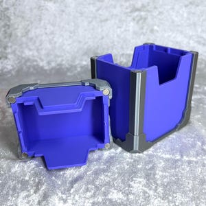 May include: A two-piece storage container featuring a vibrant purple interior and exterior shell with metallic silver-colored corner reinforcements. The design includes visible circular magnets at the corners for secure closure of the two components.