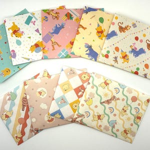 May include: A collection of nine rectangular paper envelopes featuring various Winnie the Pooh character illustrations, including Pooh, Tigger, and Eeyore, with colorful patterns of balloons, party hats, rainbows, and gifts on pastel backgrounds.