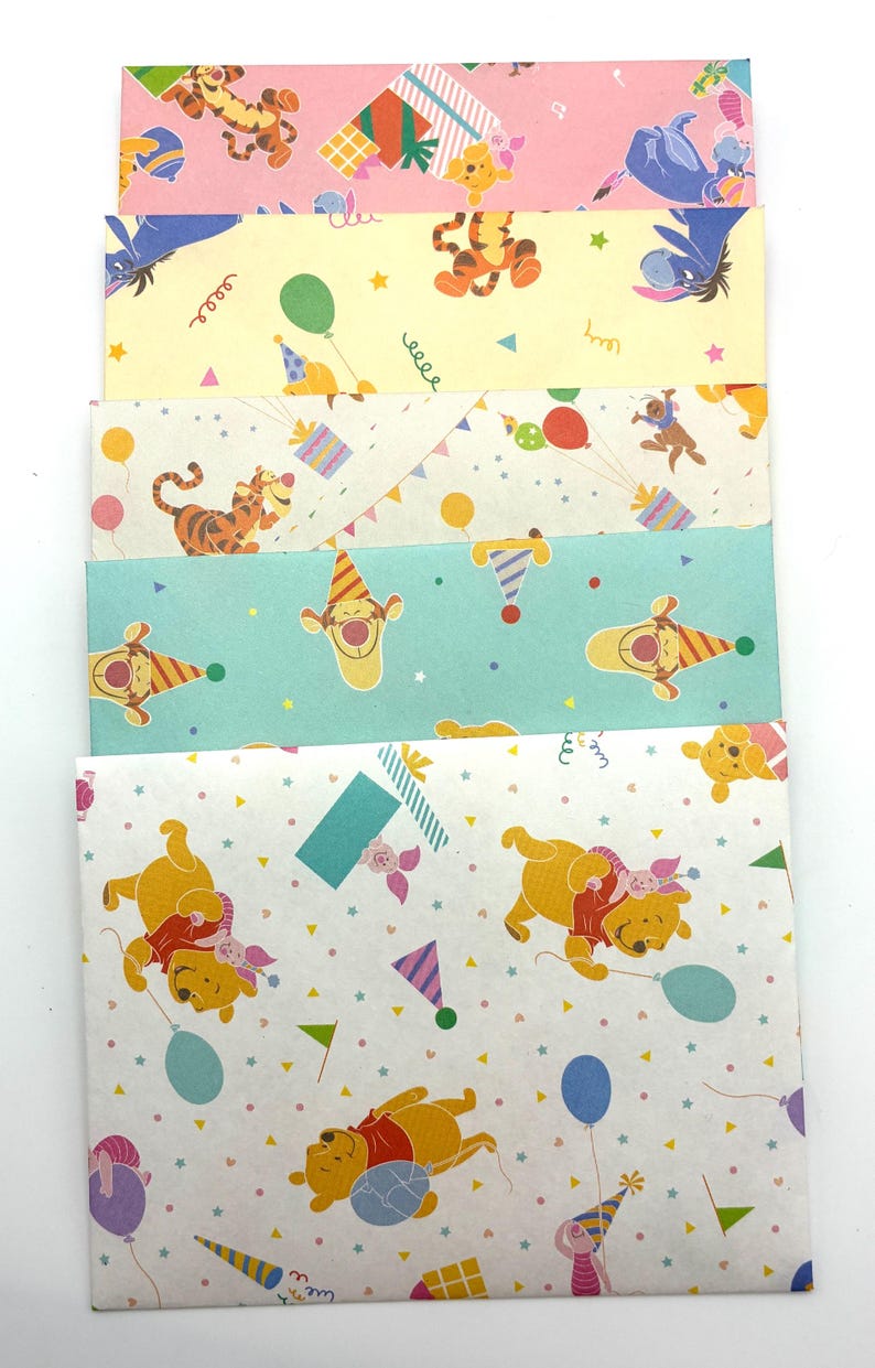 May include: A set of five rectangular paper envelopes featuring Winnie the Pooh characters including Tigger, Eeyore, and Piglet. The envelopes display colorful party-themed patterns with balloons, gift boxes, and party hats on pink, yellow, white, and teal backgrounds.