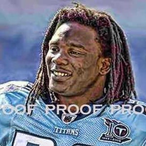 May include: A close-up portrait of a football player wearing a blue and white jersey with the word "TITANS" on the front. The player has long dreadlocks and is smiling.