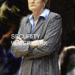 May include: A woman wearing a gray pinstripe suit jacket with her arms crossed. She is standing in front of a blurred background.