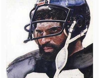 May include: A close-up portrait of a football player wearing a black and white uniform and a black helmet with a white face mask. The player has a beard and is looking off to the side.