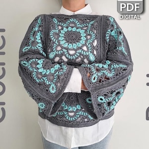 Può includere: Un maglione all'uncinetto grigio con motivi floreali turchesi. Il maglione ha maniche lunghe e un design a giogo quadrato. Le parole "Crochet Pattern" sono visibili nell'immagine.