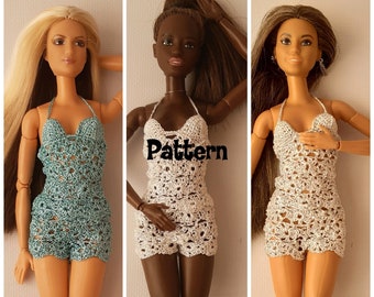 May include: Three crochet doll outfits in white, teal, and white. The outfits are halter tops with a crochet pattern and shorts. The outfits are on dolls with different skin tones.