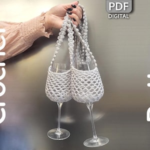 Könnte beinhalten: Zwei Sektgläser in silbernen Häkelhaltern. Die Halter sind durch einen gehäkelten Griff verbunden. Das Bild hat die Wörter "Crochet Pattern" und "PDF DIGITAL".