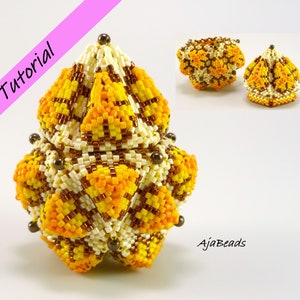 May include: A beaded, geometric, box-shaped ornament with a white, yellow, and brown colour scheme. The ornament is made of small beads and has a unique, intricate design. The ornament is a tutorial for a beaded project.