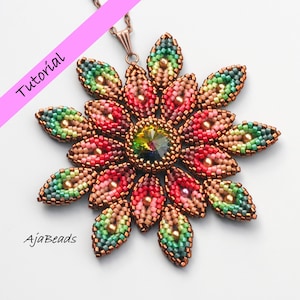 Puede incluir: Un collar con colgante floral hecho de cuentas. El colgante presenta una gema iridiscente central rodeada de pétalos en tonos rojos, rosas, verdes y dorados. El texto "Tutorial" y "AjaBeads" son visibles.