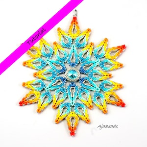 May include: A beaded snowflake ornament with a central jewel and a pattern of blue, yellow, and orange beads. The ornament has a silver-coloured hanging loop. The word "Tutorial" is written on a diagonal pink stripe.