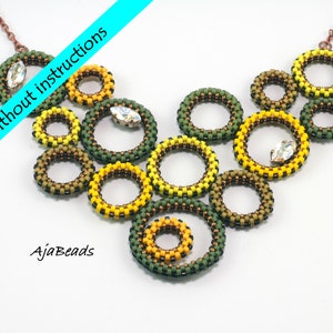 Könnte beinhalten: Ein Halsketten-Set mit kreisförmigen Perlenelementen in Grün, Gelb und Braun. Die Halskette hat Kristallakzente und eine kupferfarbene Kette. Das Bild enthält den Text "Kit ohne Anleitung" und "AjaBeads".