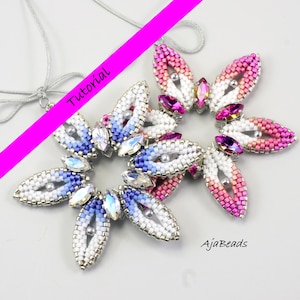 Può includere: Due ciondoli a forma di fiore con perline con un cordino d'argento. I ciondoli presentano perline bianche, rosa e blu con accenti di cristallo. La parola "Tutorial" è scritta in rosa sull'immagine. È visibile anche il marchio "AjaBeads".