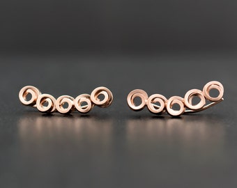 Brincos minimalistas em formato de círculo, em prata de lei com detalhes em ouro rosa.