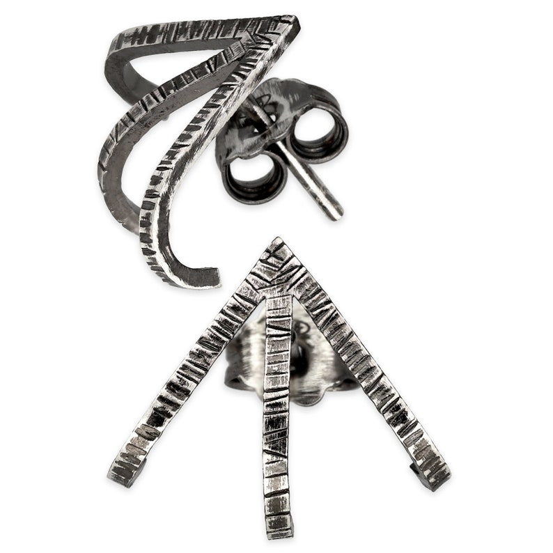 May include: A pair of silver earrings with a geometric design. The earrings are made of two pieces, one a curved shape and the other a triangle shape. Both pieces have a textured surface.