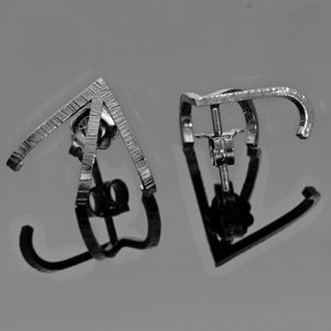 May include: A pair of silver earrings with a geometric design. The earrings are made of two pieces of metal that are joined together at the top. The earrings are designed to be worn with the metal pieces facing outwards.