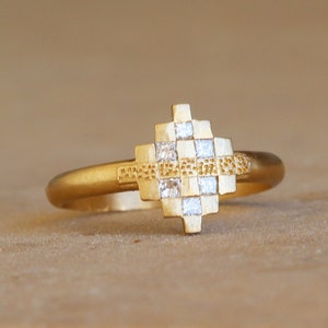 May include: A gold ring with a geometric design set with small diamonds.