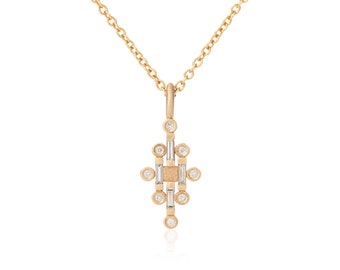 May include: A gold pendant necklace with a geometric design. The pendant has a central rectangular cluster of clear stones, surrounded by smaller round stones. The chain is delicate and gold-coloured.