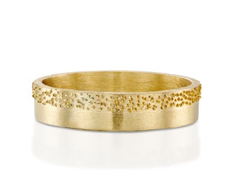 May include: A gold band ring with a textured band. The band has a row of small, raised dots.