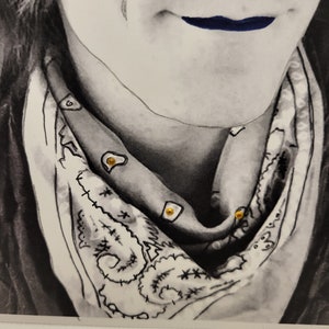 May include: A black and white drawing of a person wearing a bandana with gold accents. The bandana has a paisley pattern and is tied around the person's neck. The person's lips are painted a dark blue colour.