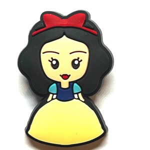 Puede incluir: Una figura de dibujos animados de Blancanieves, con un vestido amarillo, mangas azules y blancas y un lazo rojo. El personaje tiene cabello negro y una expresi&oacute;n sonriente. La imagen es un primer plano sobre un fondo blanco.