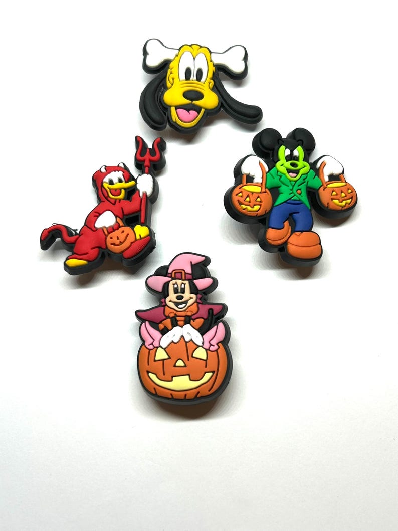 K&ouml;nnte beinhalten: Eine Sammlung von Halloween-Charms mit Charakteren. Die Charms zeigen Pluto, Donald Duck als Teufel, Mickey Mouse und Minnie Mouse. Jeder Charm ist farbenfroh und mit Halloween-Elementen wie K&uuml;rbissen und Kost&uuml;men gestaltet.