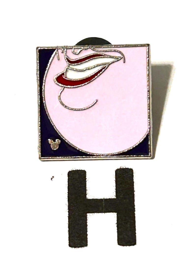May include: Square enamel pin featuring a stylized mouth with a red, white, and silver design on a pink background. The pin has a silver border and a dark blue edge. A small Mickey Mouse icon is visible. A large black letter "H" is below the pin.