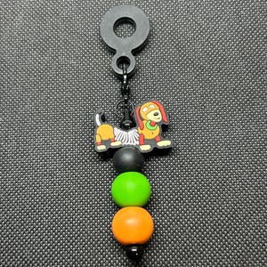 May include: A white ceramic mug with a black handle and the text "But First, Coffee" in a bold, black font. The mug is set against a blurred background, suggesting a cozy setting.