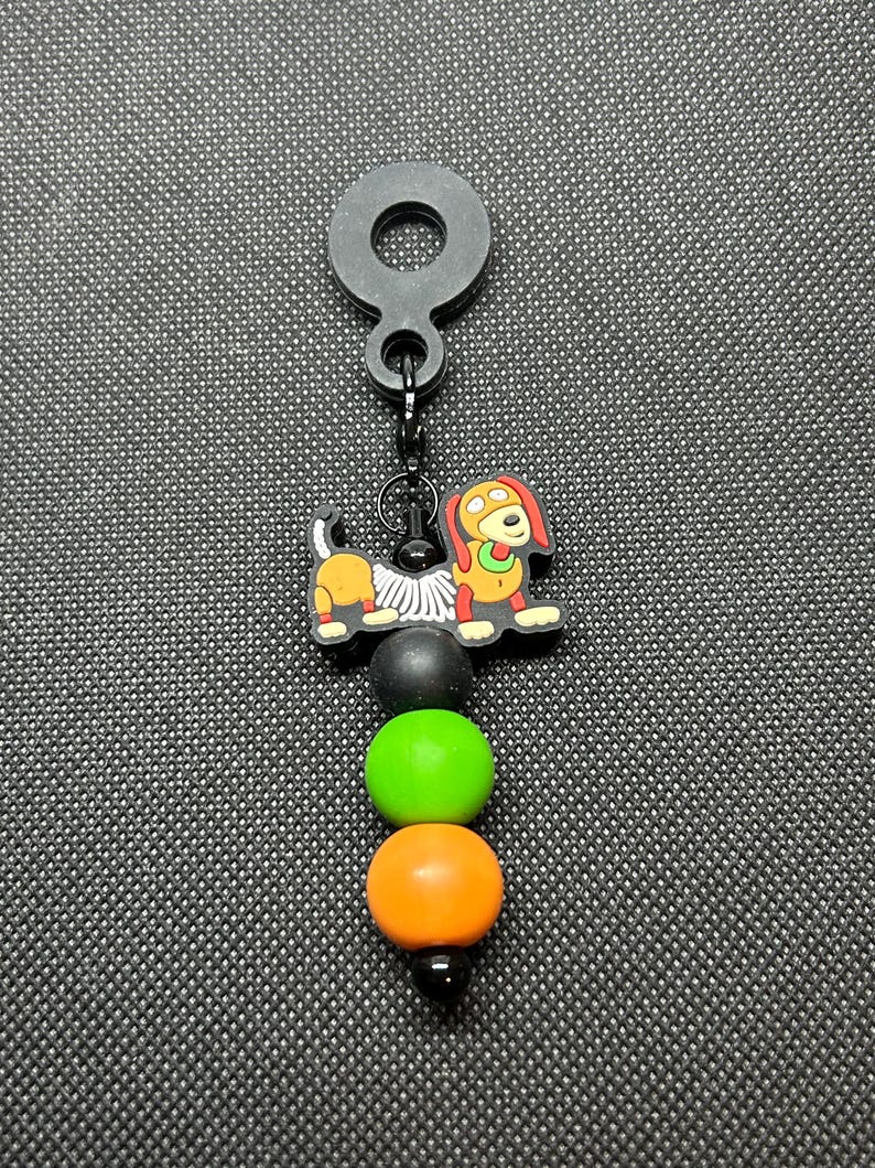 May include: A white ceramic mug with a black handle and the text "But First, Coffee" in a bold, black font. The mug is set against a blurred background, suggesting a cozy setting.