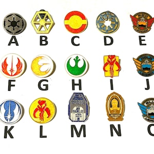 Puede incluir: Una colección de pines temáticos de Star Wars, con varios símbolos y personajes. Los pines son de varias formas y colores, incluyendo rojo, amarillo, azul y plateado. Cada pin está etiquetado con una letra de la A a la O.
